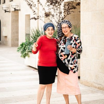 2 women smiling for camera outside