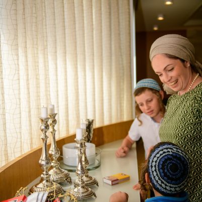 Mother lighting candles with sons 1