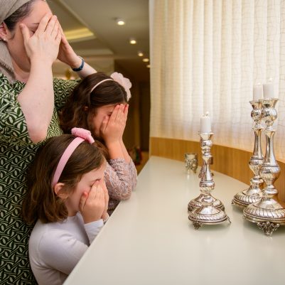 Mother and daughters lighting candles 2