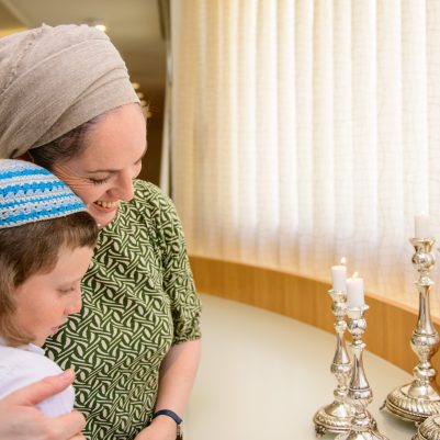 Mother with son next to Shabbat candles