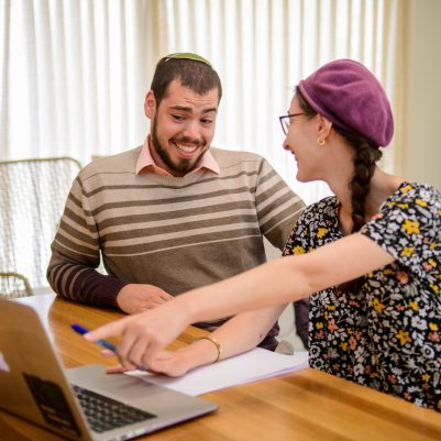 Couple laughing at computer screen 1