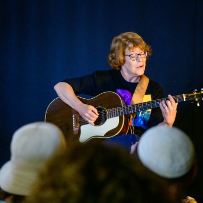 Woman performing guitar in concert 1