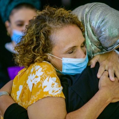 2 נשים מתחבקות עם מסכות