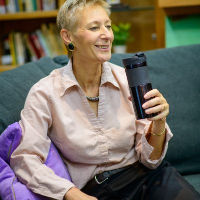 אישה מחזיקה ספל קפה