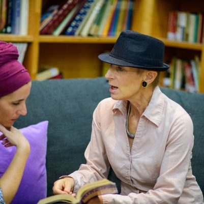 Two women discussing book in library 1