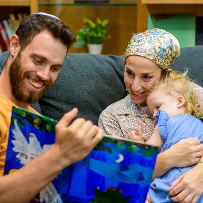 Family reading book on couch 1