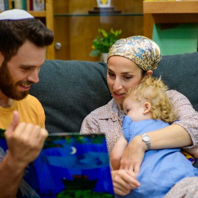 Family reading book on couch 2