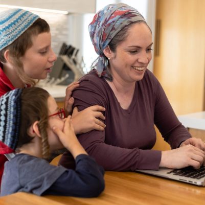 Mother working on laptop with sons interrupting 2