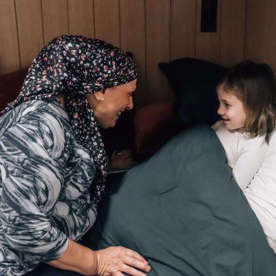 Grandmother putting granddaughter to sleep