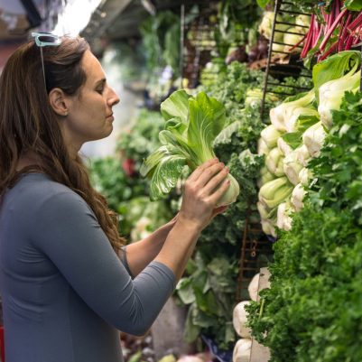 Woman examining vegetables at supermarket