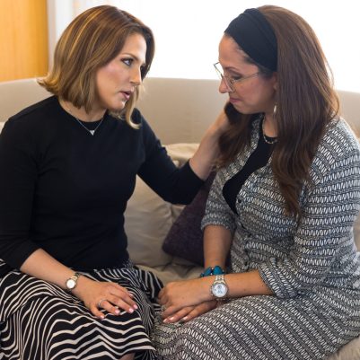 Woman comforting friend with hand on shoulder
