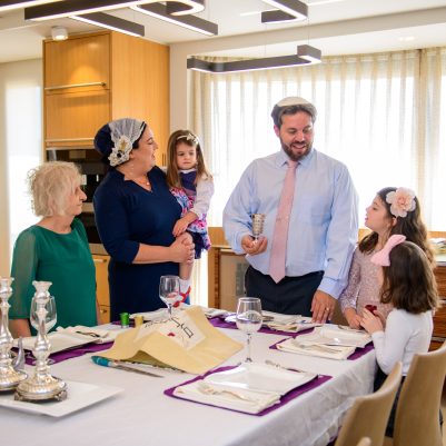 Father making kiddish for family members 2