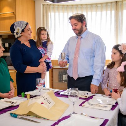 Father making kiddish for family members standing up 3