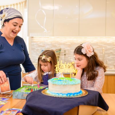 Mother and daughters playing games at birthday party 1