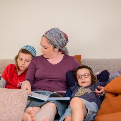 Mother reading a book to sons 2