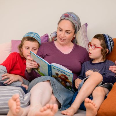 Mother reading a book to sons 3