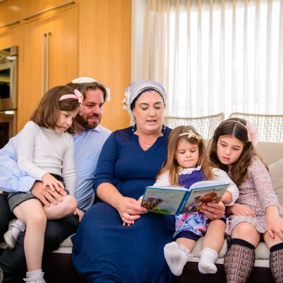 Family reading a book on the couch