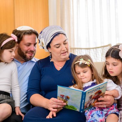 Family reading book on the couch 3