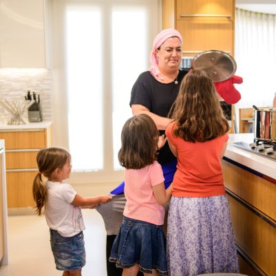 Daughters interrupting mother cooking 1
