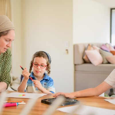 Mother and sons doing art and crafts on the table