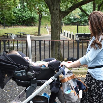 Mom pushing baby in the stroller at park
