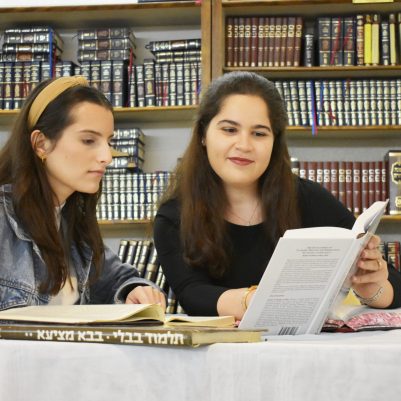 Two young women learning Torah