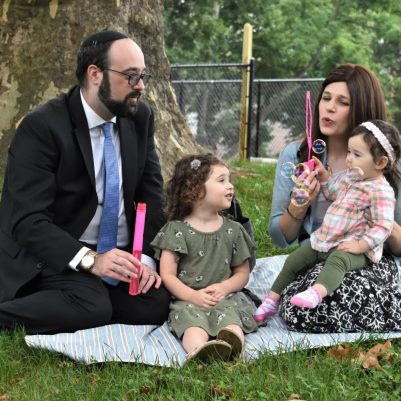 Young family at park blowing bubbles