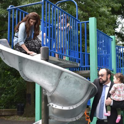 Mother and toddler playing on slide