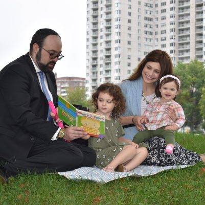 Family reading a book on the grass