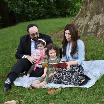 Family reading book on the grass