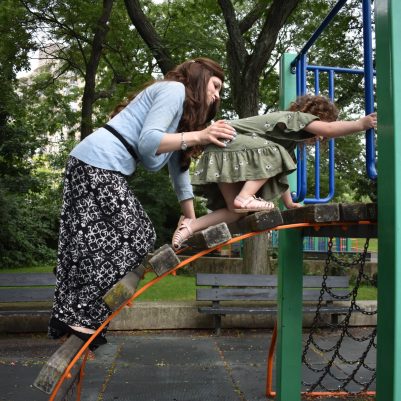 Mother helping daughter at park on jungle gym 2