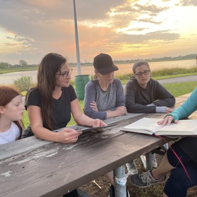 Women and girl learning outside