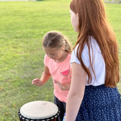 Young girl playing drum in park