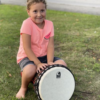 Young girl playing a drum 1
