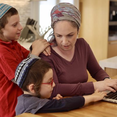 Mother working from home with her two sons next to her 1