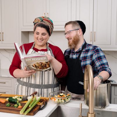 Couple looking at cookbook in kitchen