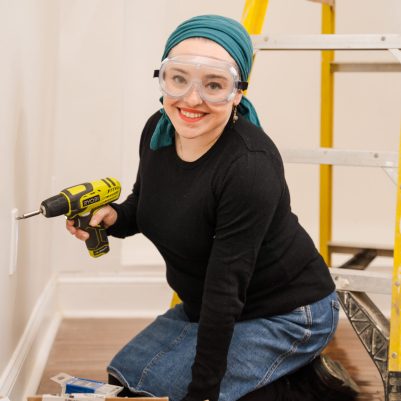 Woman with cordless drill and safety goggles