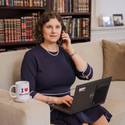 Woman talking on phone and working on laptop 1