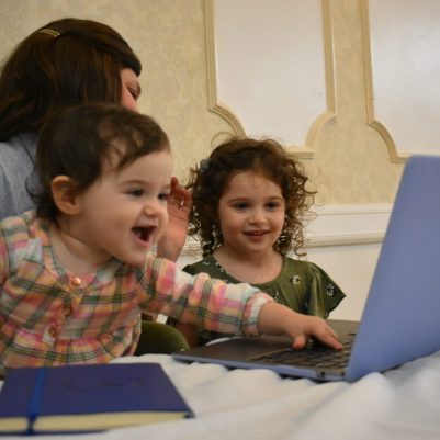 Kids looking at computer with mother