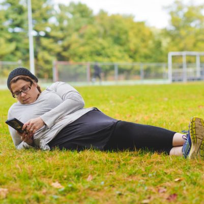 Woman sitting on grass looking at phone