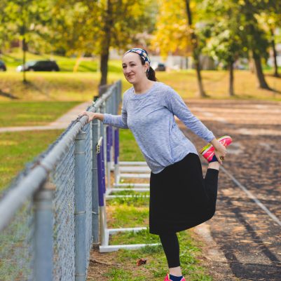 Woman stretching next to fence 2