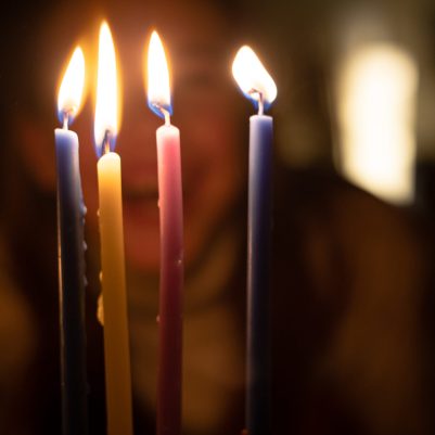 Girl looking at chanukah candles