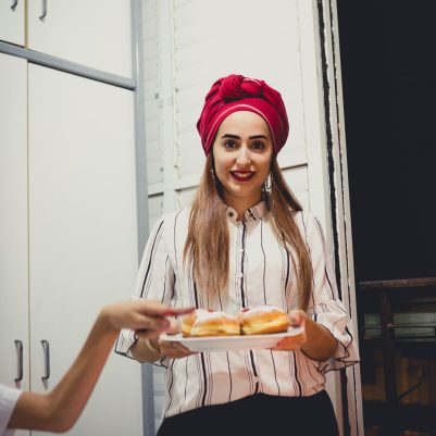 Woman holding plate of sufganiyot