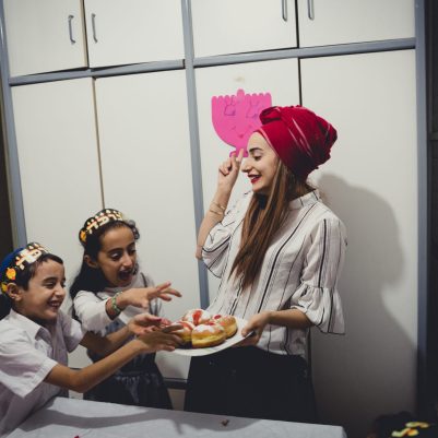 Mother giving kids sufganiyot