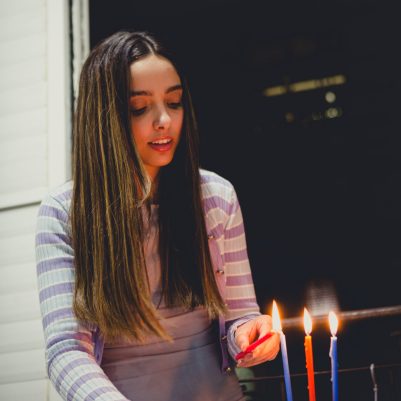 Young woman lighting chanukkia 2