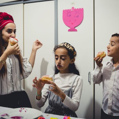 Mother and kids eating sufganiyot 2