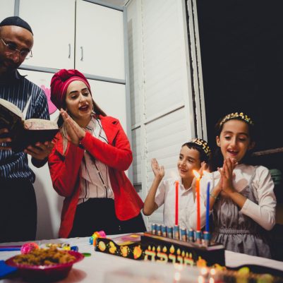 Family singing and lighting chanukkia 1