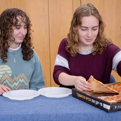Two young women eating pizza 3