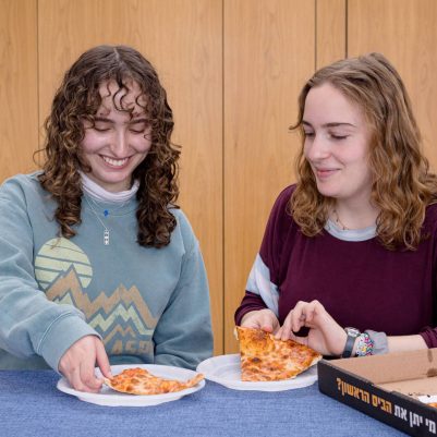 Two young women eating pizza 1