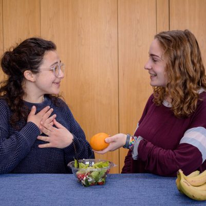 Young woman offering friend food 2